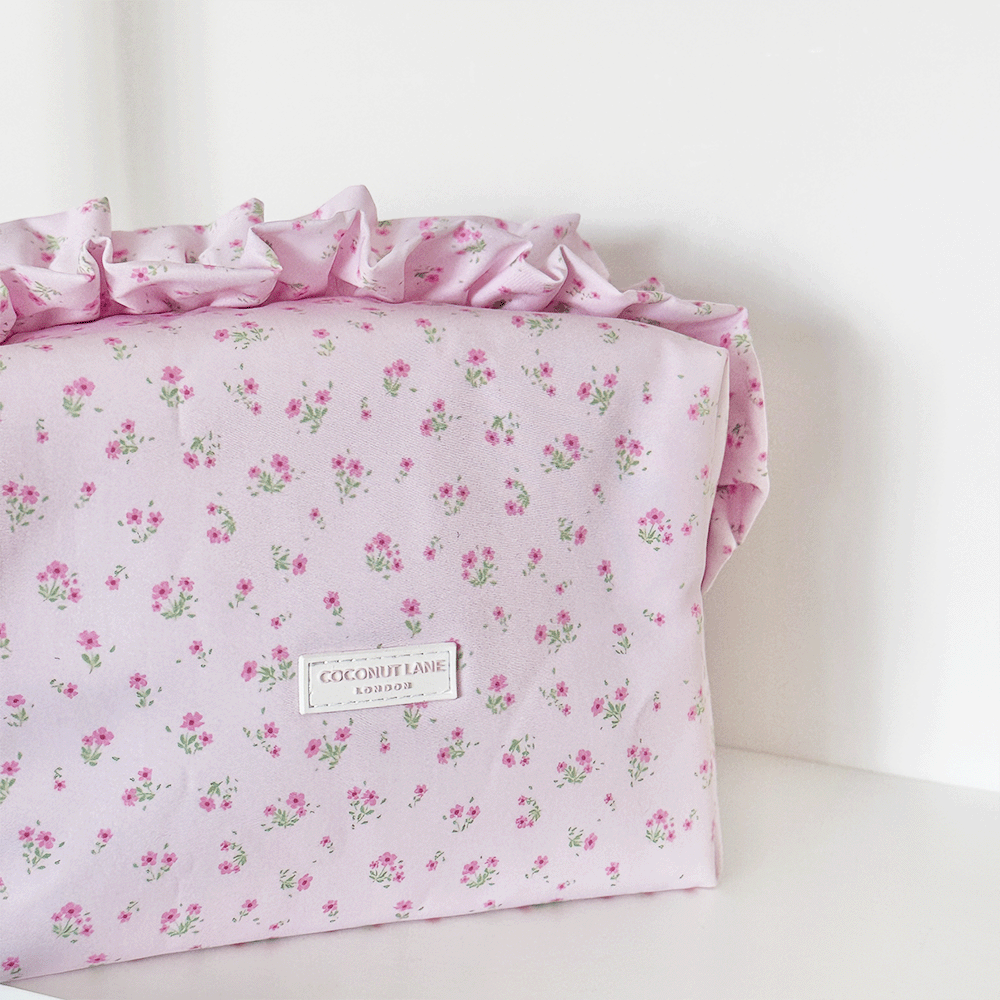 Pink floral Makeup Bag with ruffle trim and Coconut Lane logo.