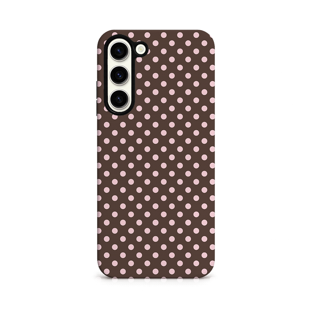 A smartphone case with a brown background featuring a pattern of evenly spaced light pink polka dots. The phone's triple camera is visible at the top left.