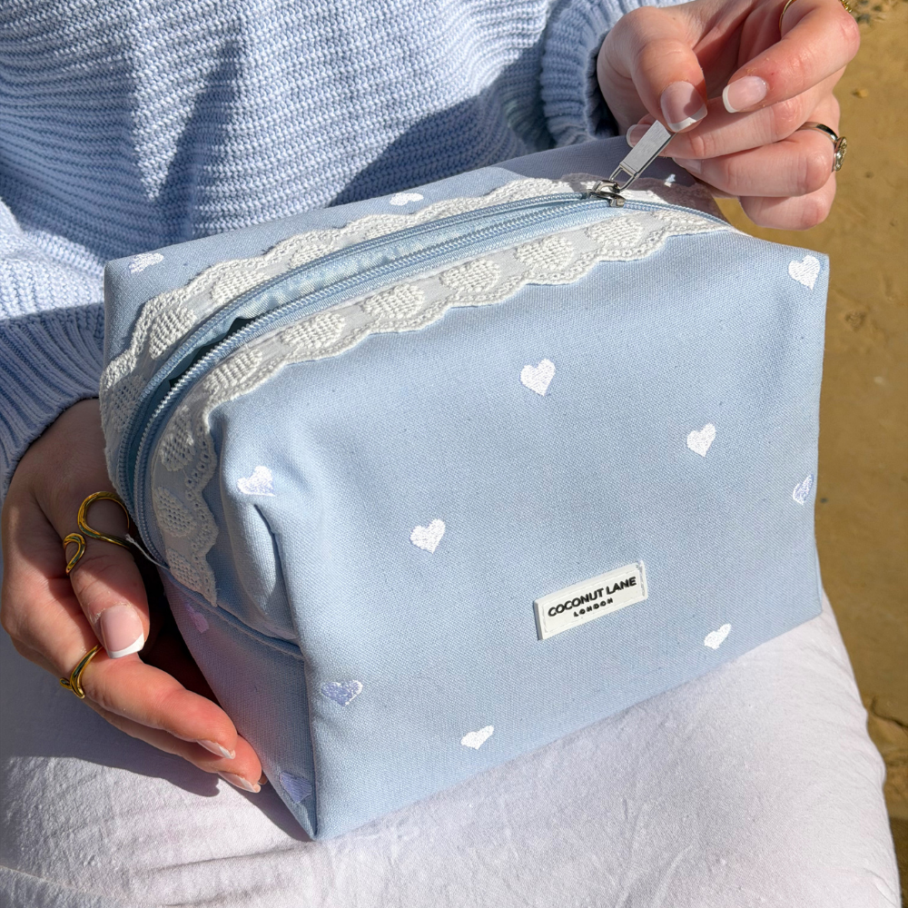 Close up image of the Blue Hearts Makeup Bag on girls lap 