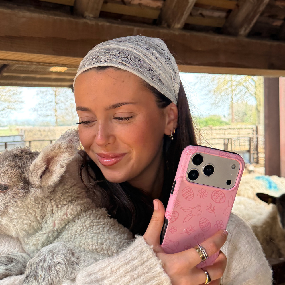 Girl holding lamb and blush bunny tough phone case in hand