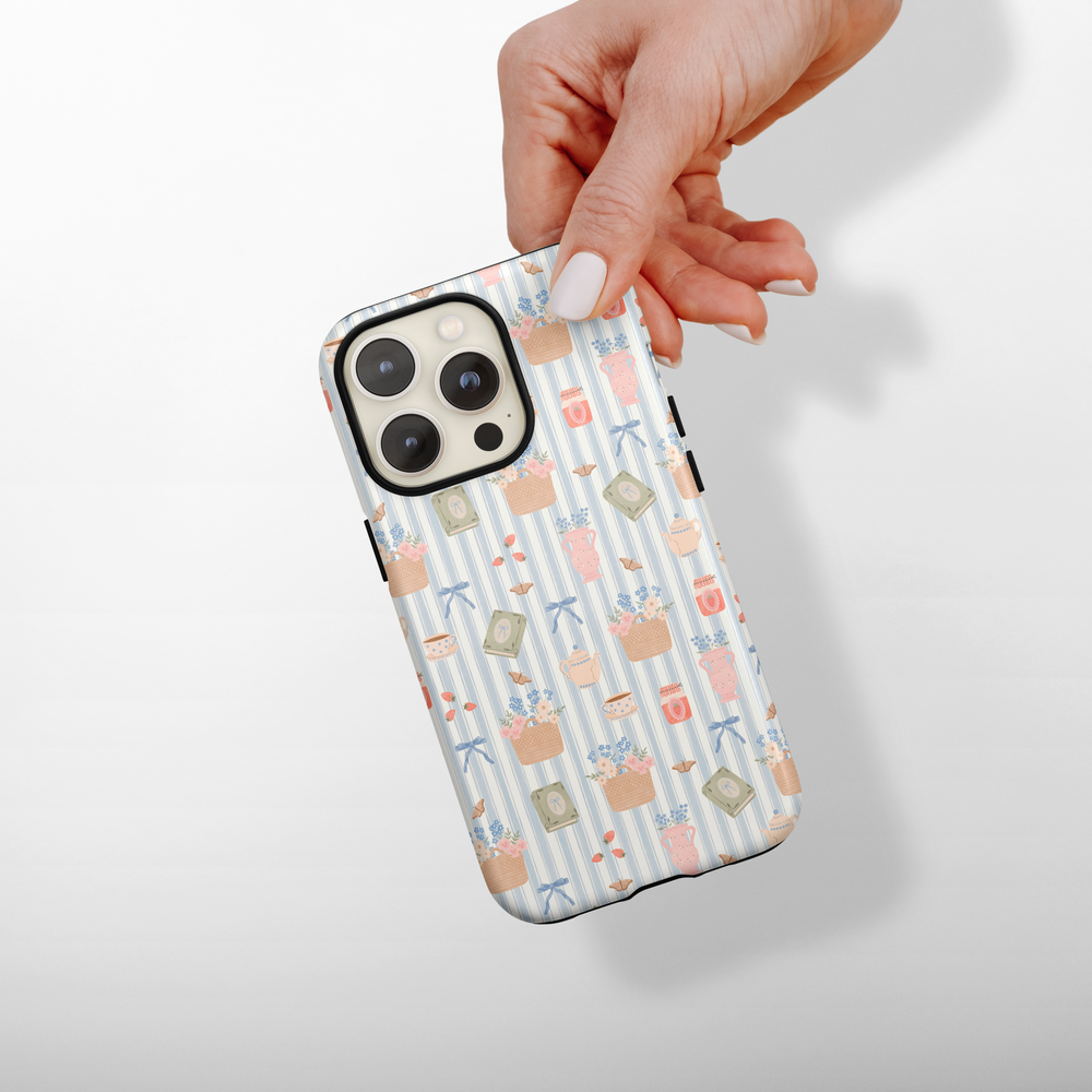 Phone case with floral pattern held by a hand on a light background