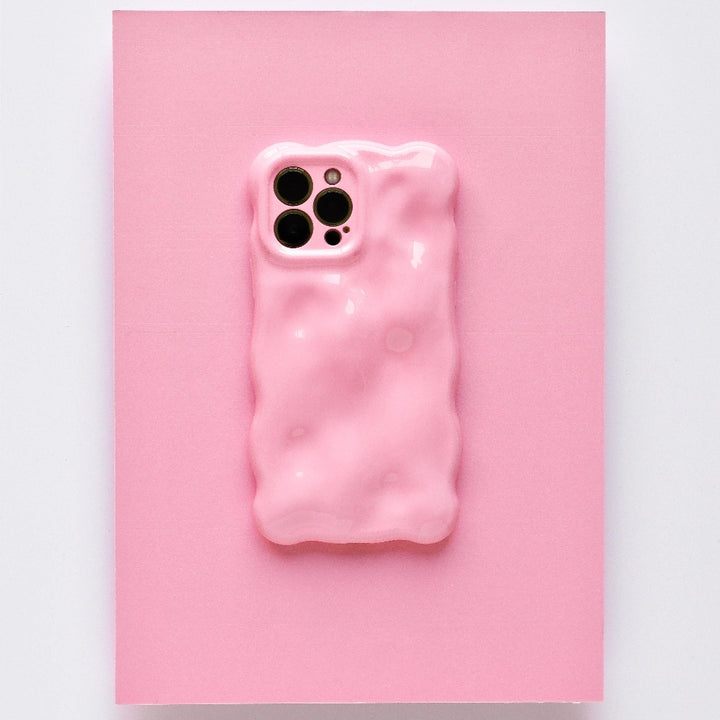 A chic and colorful upgrade, this smartphone features the Coconut Lane 3D Gummy Phone Case - Pink, showcasing a textured pink design with a melting effect set against a matching pink background. The unique, irregular surface enhances the phone's triple camera setup visible at the top left corner.