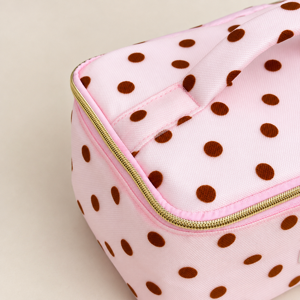 Top view of pink mesh vanity case with brown polka dots and a padded polka dot top handle.