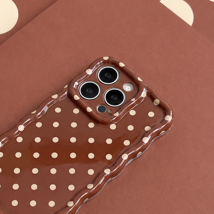 Glossy brown phone case with small cream polka dots and a wavy edge.