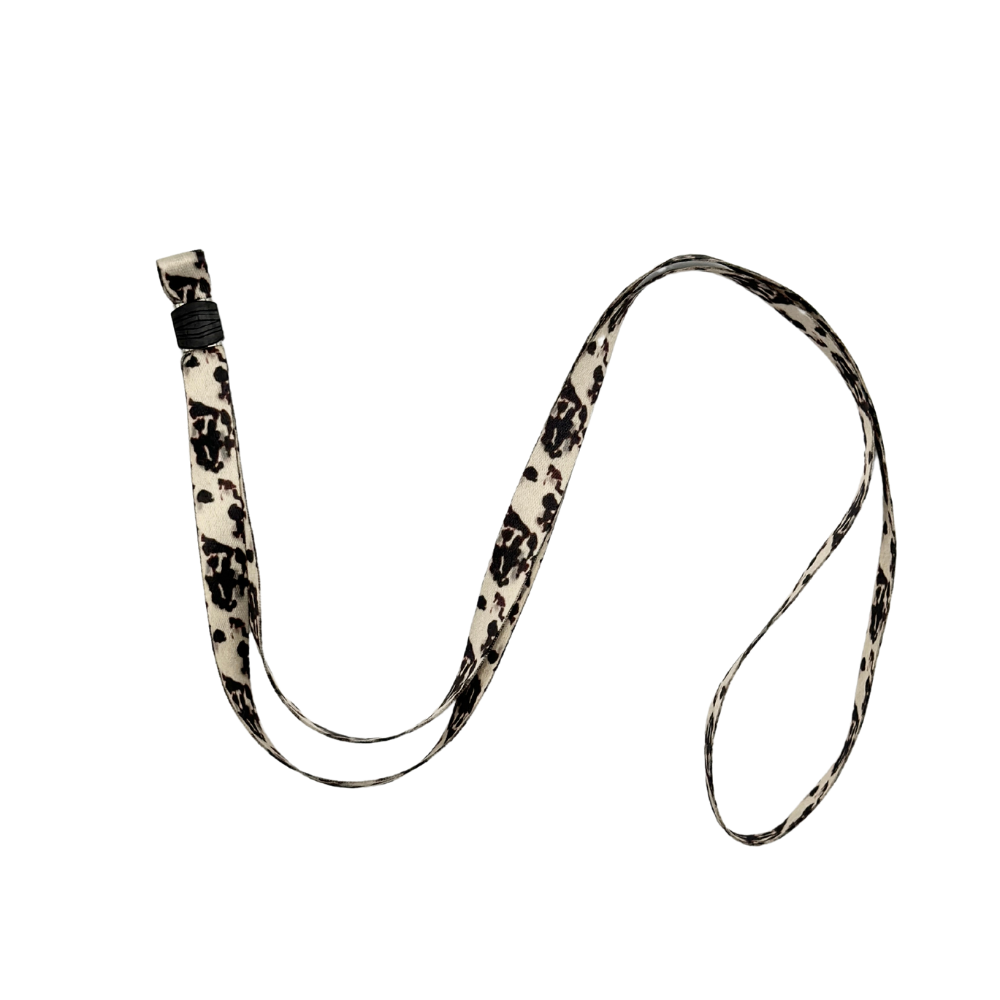 A Universal Phone Lanyard Patch Bundle by Coconut Lane, featuring a black and white patterned lanyard with a plastic clip, lies on a plain white background. The fabric lanyard showcases a swirling, abstract design and serves as an essential accessory for added phone security.