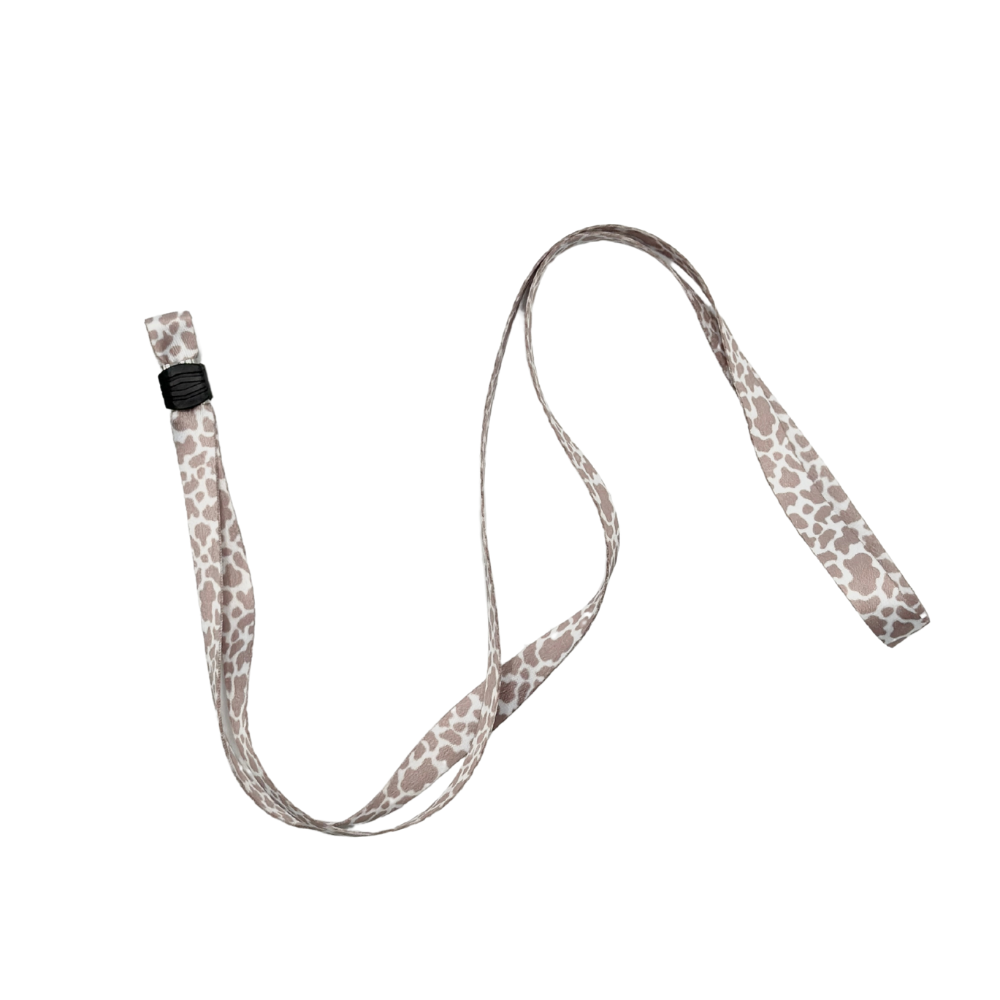 A thin, white fabric belt with a grey leopard print pattern and a black plastic buckle is laid out in a loose, curving shape against a white background. It resembles the sleek design of Coconut Lane's Universal Phone Lanyard Patch Bundle—a perfect phone accessory for added security.