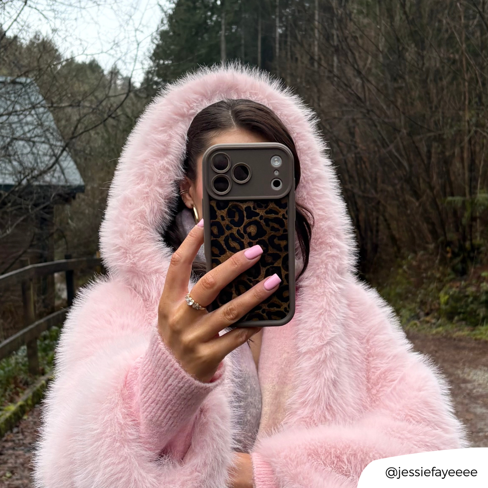 Girl on a walk with mocha leopard phone case in a pink fluffy coat