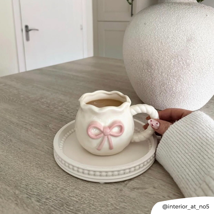 Bow Mug being held on table