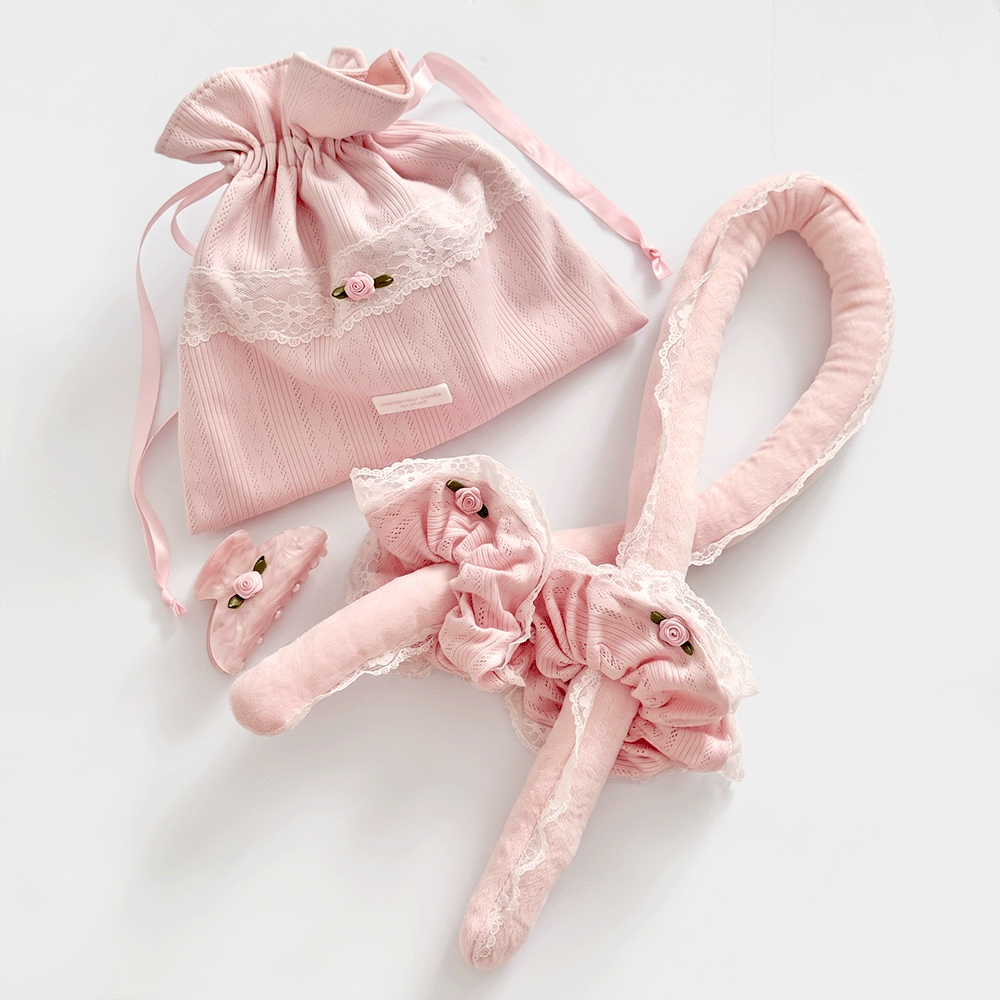 Soft pink heatless curling rod, with matching scrunchies and claw clip. Comes in a pink pointelle fabric storage bag with Coconut Lane logo badge. White lace trim detailing.