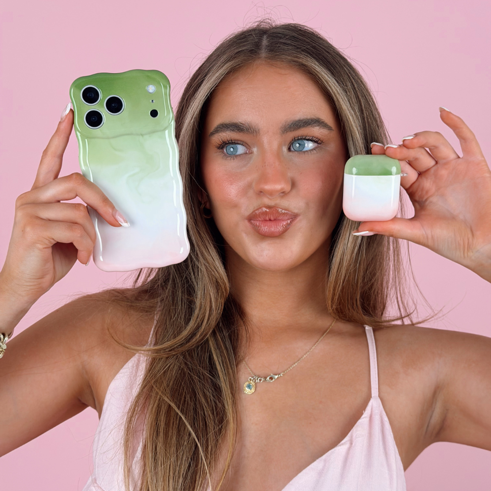 Girl holding wavy strawberry matcha phone case and airpods studio shoot in pink