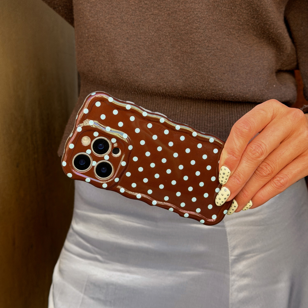Close up of brown and blue polka dot phone case matching to outfit