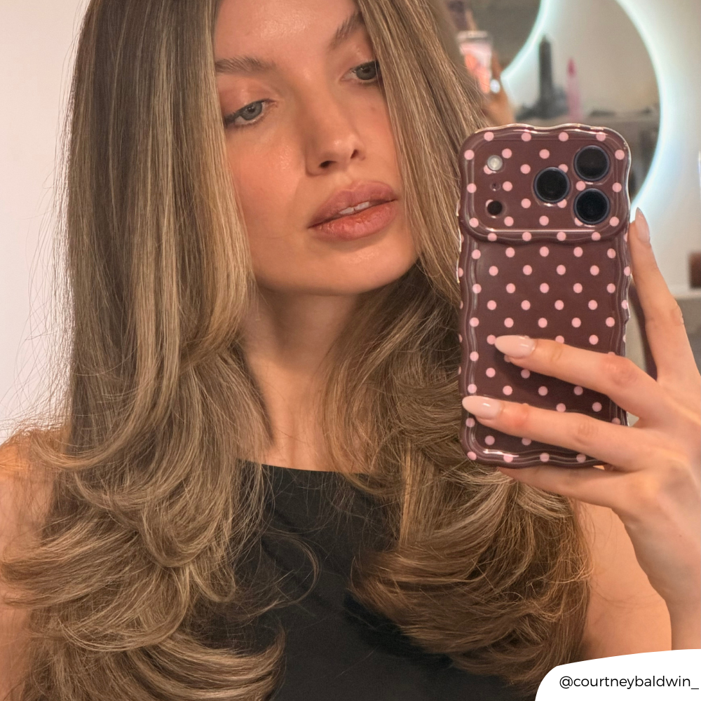 A girl getting her hair done taking selfie with the Wavy Phone Case Brown Polka Dot