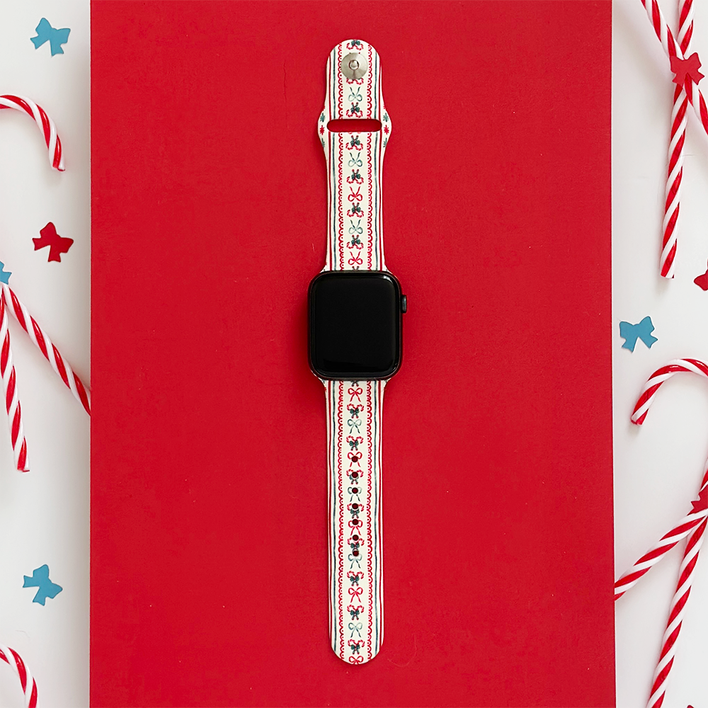 Coconut Lane Let It Bow Apple Watch strap, red background with candy canes and star confetti.