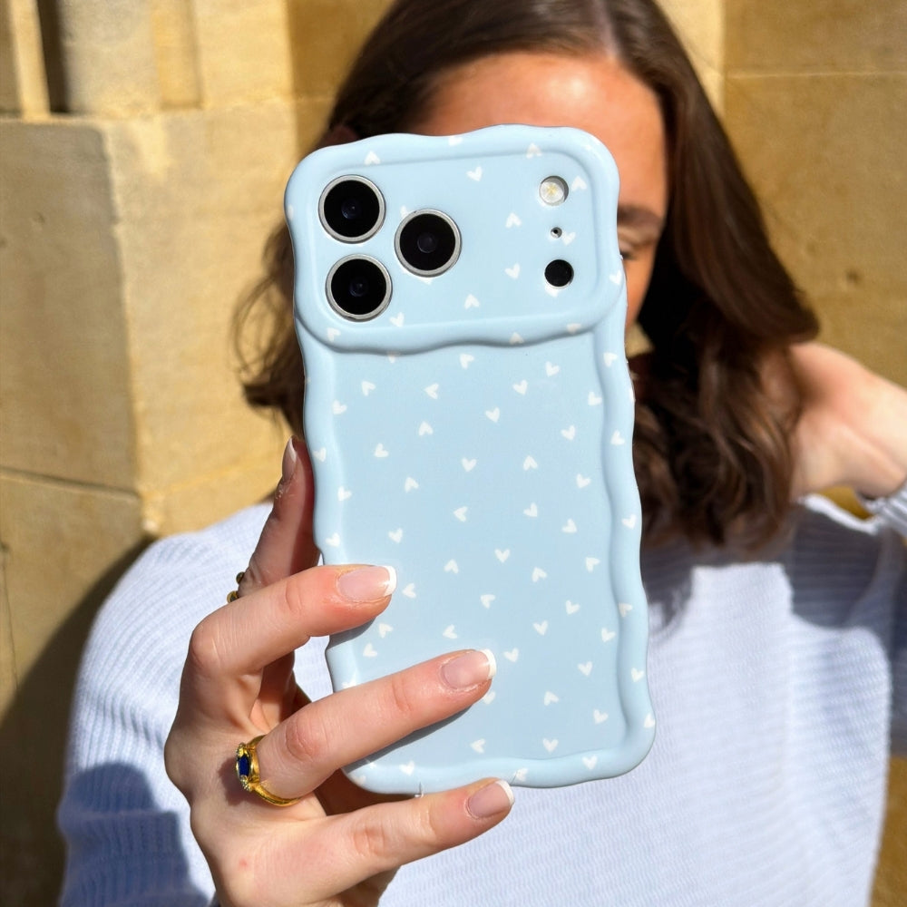 Girl holding Powder Blue hearts phone case in the sun