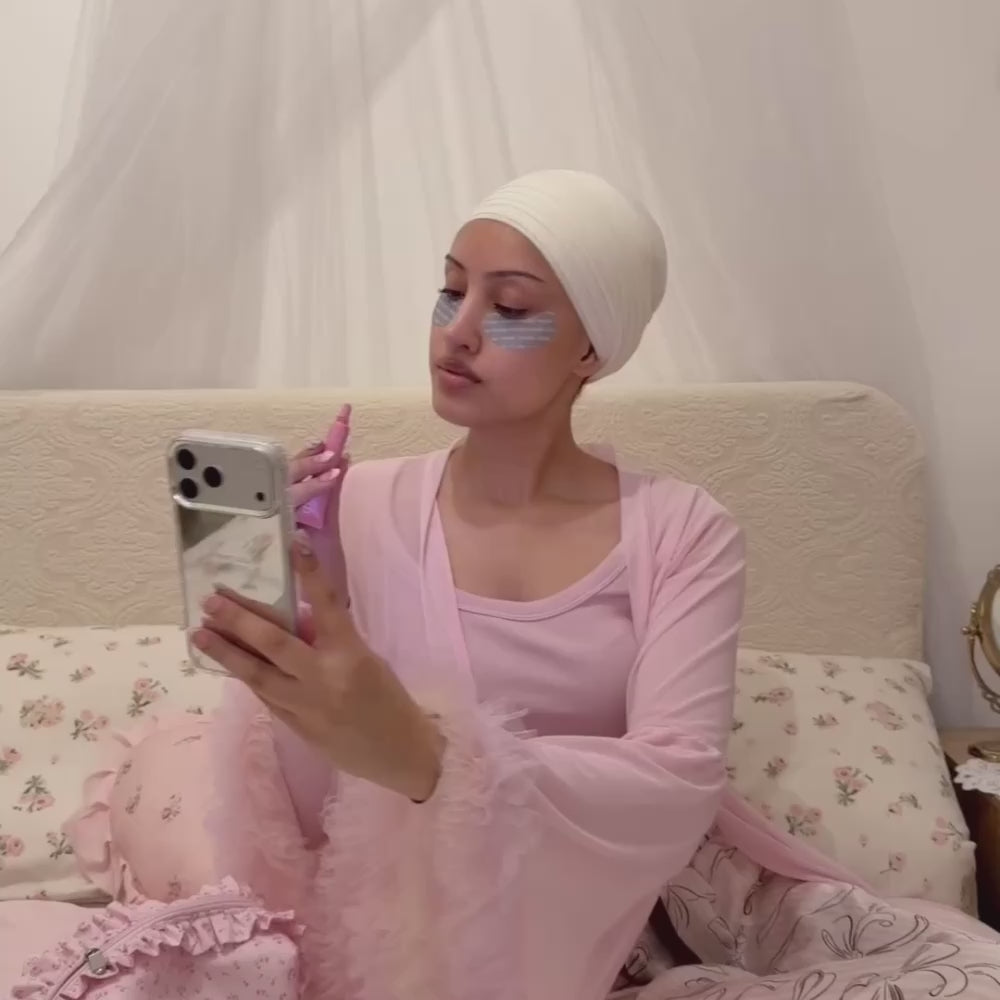 Woman taking a selfie, applying lipbalm, holding an iphone in a mirrored phone case with the text "don't call just text" printed on the back. 