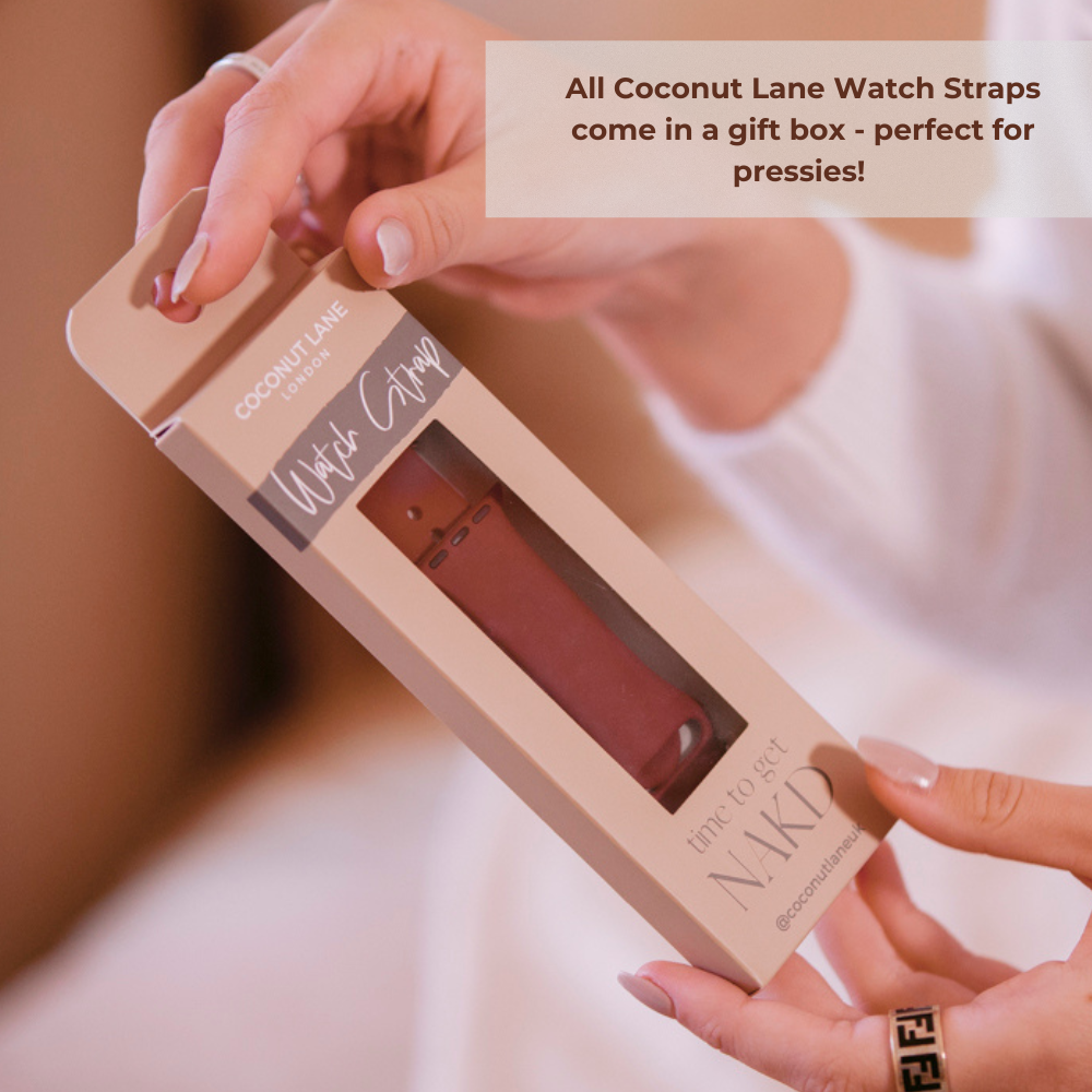 A person is holding a boxed NAKD Apple Watch Strap labeled "time to get NAKD." The box has a window displaying a sky blue silicone strap inside. A caption in the upper right corner reads, "All Coconut Lane Watch Straps come in a gift box - perfect for pressies!